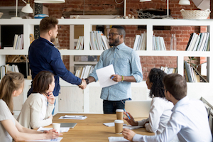 Diverse workteam congratulating a team member