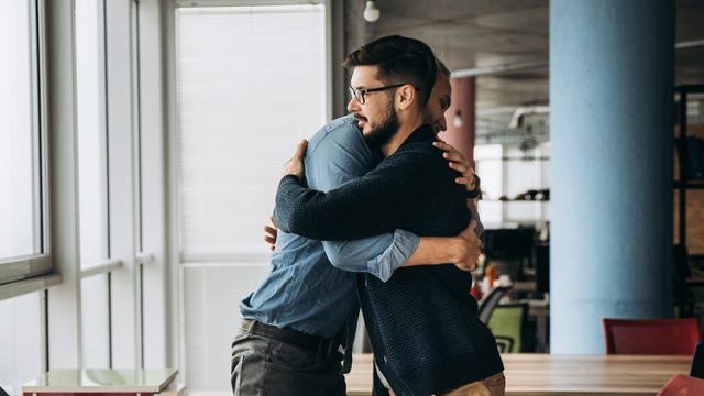 Employees hugging at work